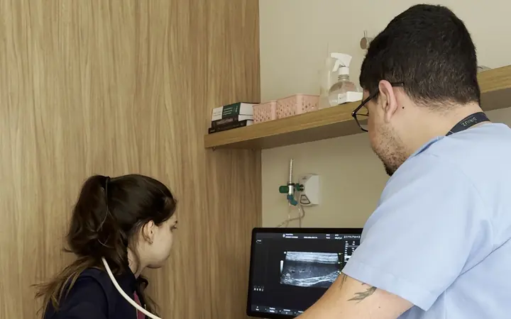 Exame de ultrassom acompanhado pelo monitor na sala de imagem